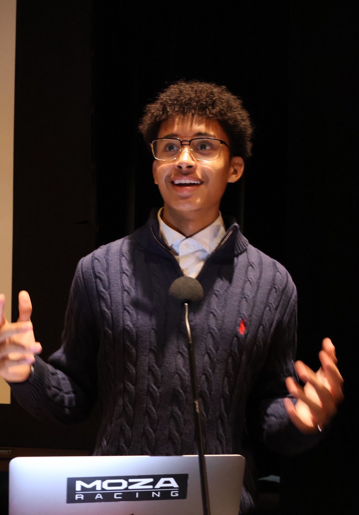 Geovanie Joseph-Velasquez, Founder of Margevue, speaking on stage with a microphone.